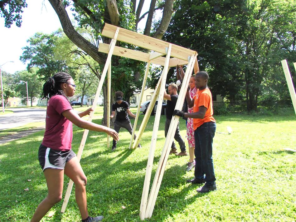 Tired-a-Lot crew members raise a structure of the clubhouse they designed.