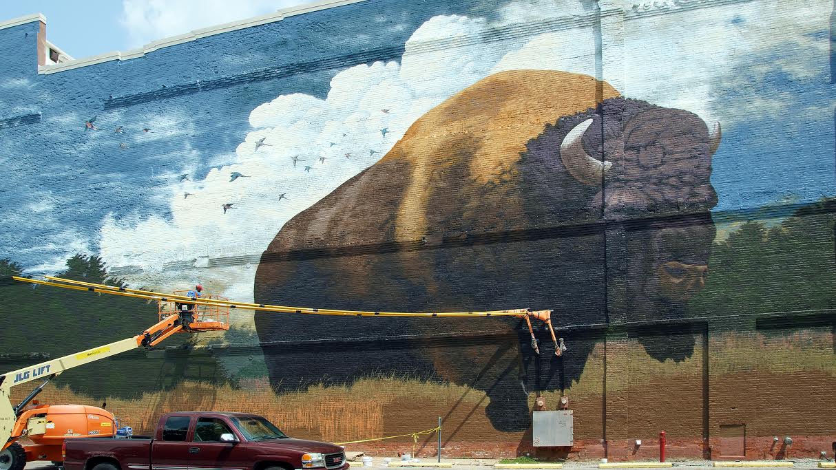 Tim Parsley paints a bison mural on the Landing in downtown Fort Wayne.