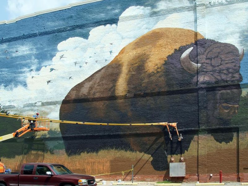 Tim Parsley paints a bison mural on the Landing in downtown Fort Wayne.