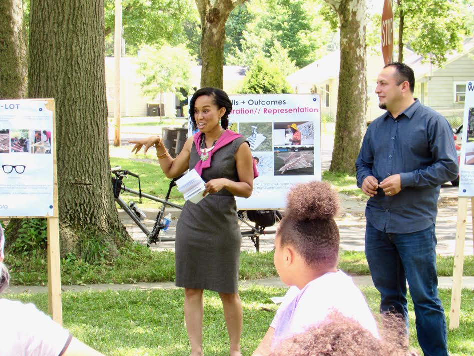 Réna Bradley, director of the Tired-a-Lot project, shows community members in Mount Vernon Park the campers’ designs.