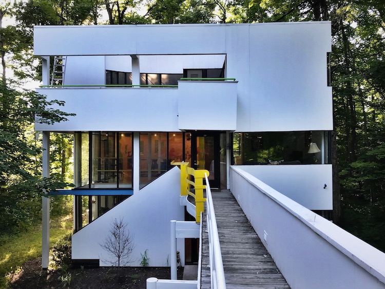 A bridge-like walkway leads out from the second storey of the house.