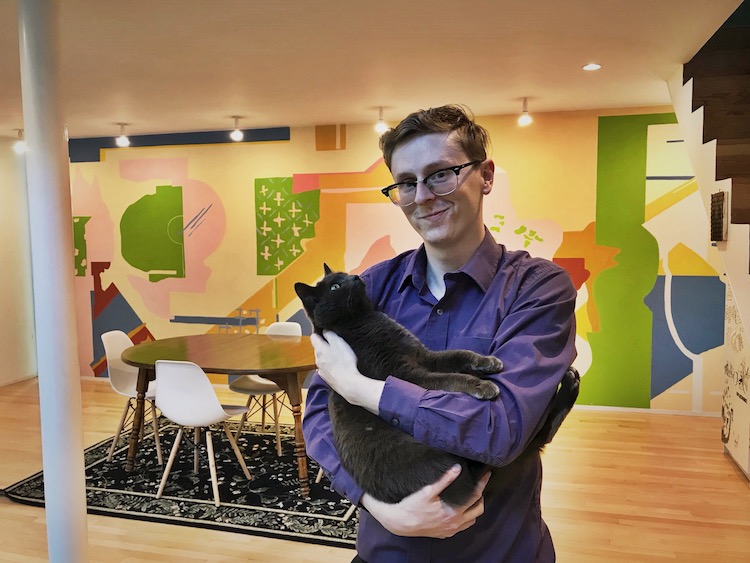 Evan Mulvihill, 27, bought the Hanselmann House. Behind him is a mural by Michael Graves.