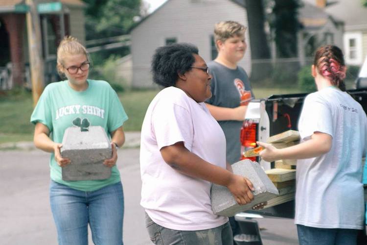 NeighborLink volunteers unload materials at a project site.