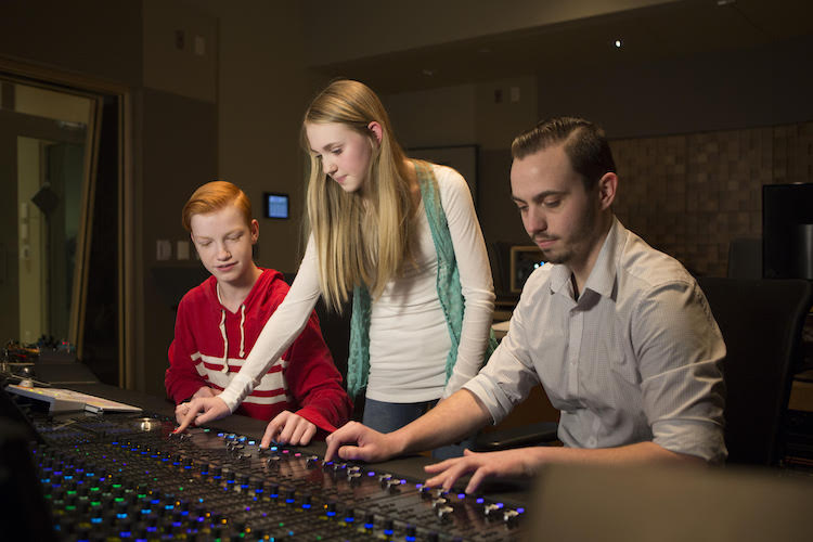 Professional musicians help students experiment with sound equipment at Rock Camp.