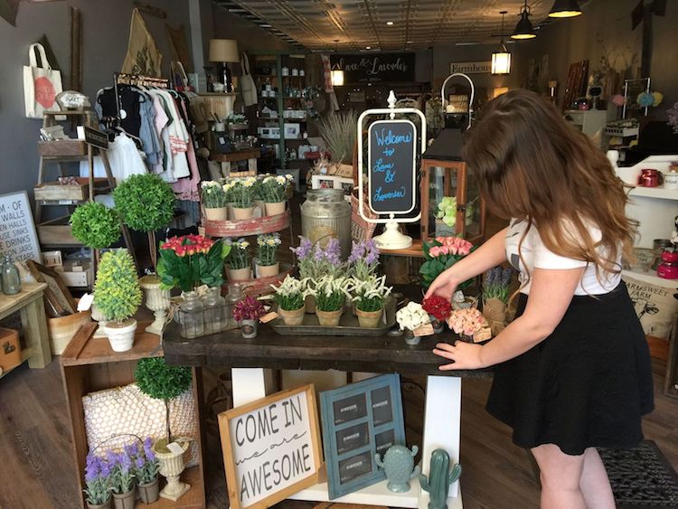 Isabelle Anglin, retail associate, arranges a display at Lane and Lavender.