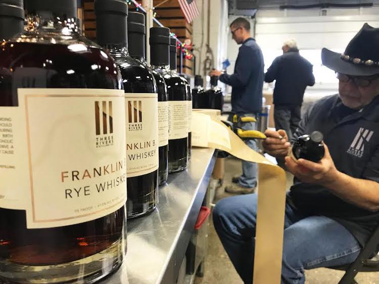 Labeling at Three Rivers Distilling Co. is done by hand.