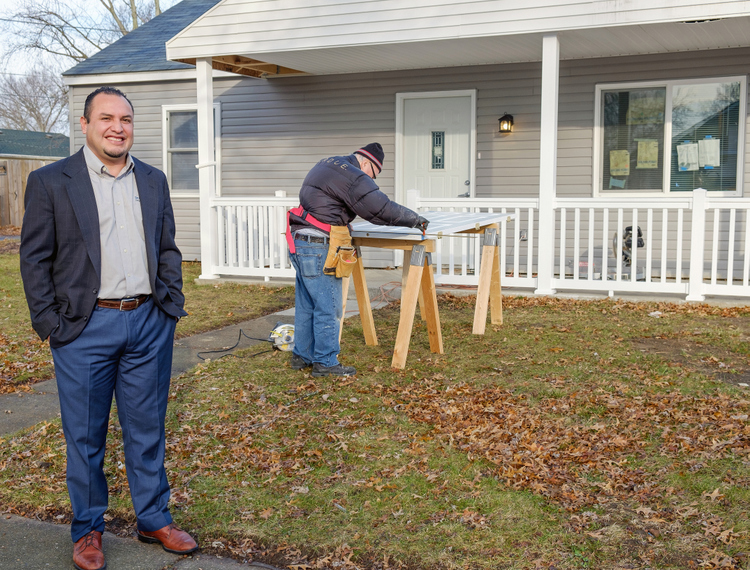 Mondragon and a community volunteer outside of a model home Bridge of Grace help renovate at 1045 E. Fairfax Ave.