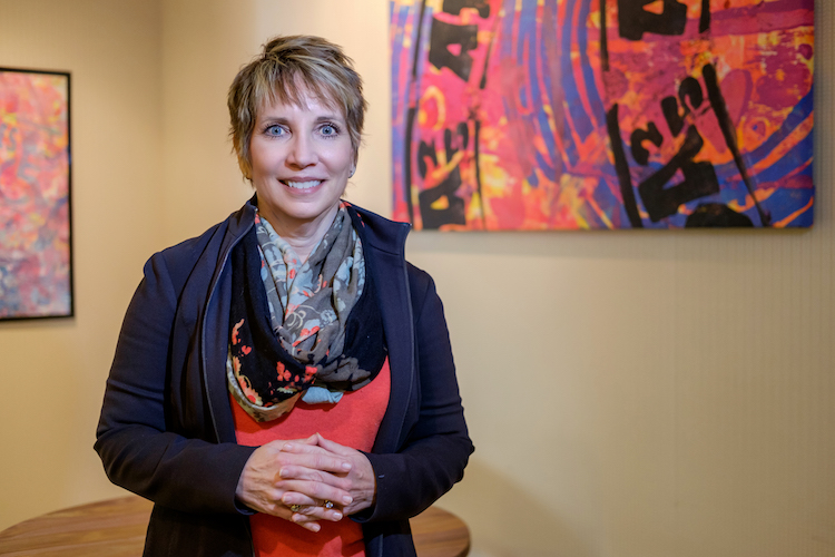 Patti Hays at the AWS Foundation with artwork representing the Americans with Disabilities Act.