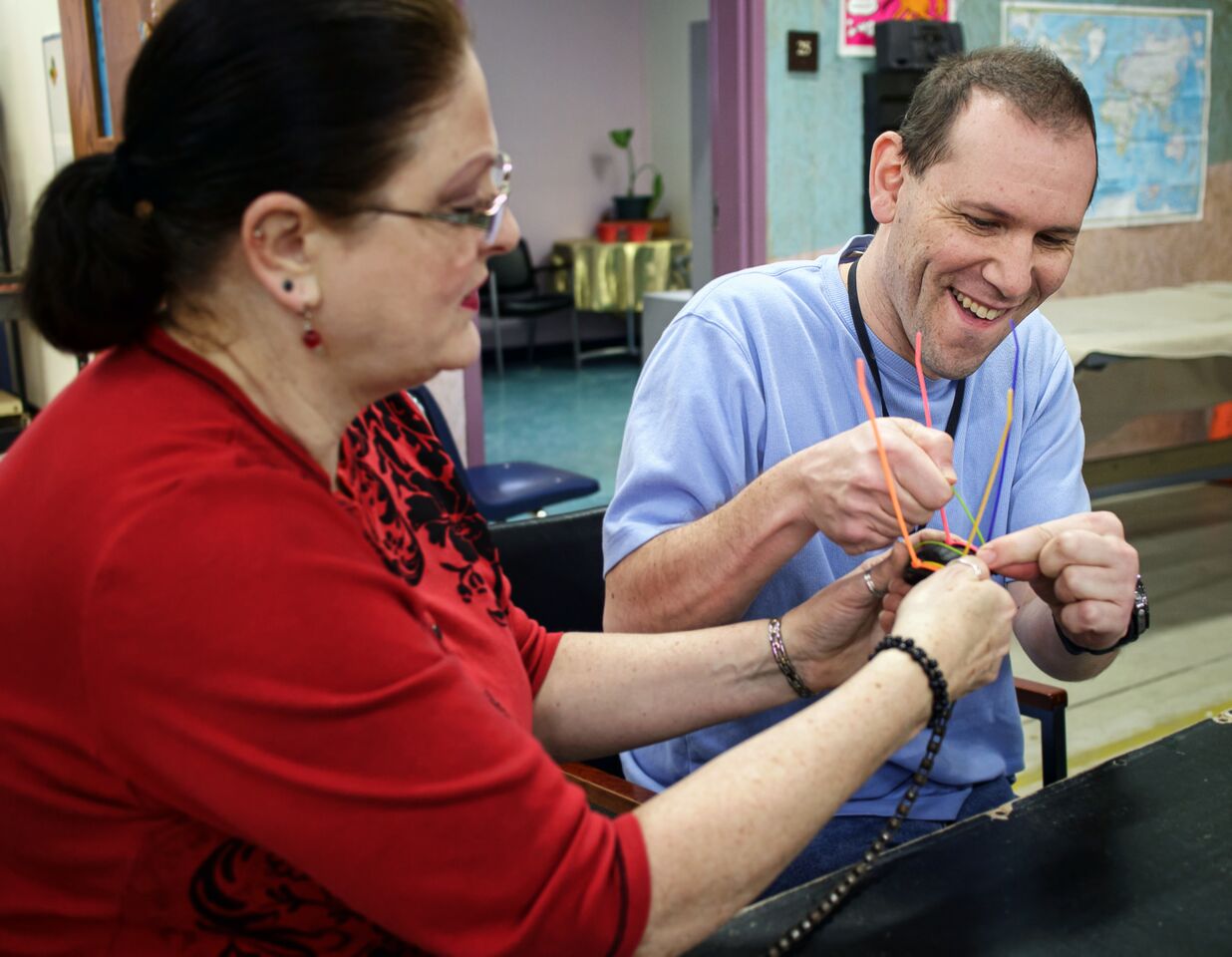 A client at Easterseals Arc of Northeast Indiana gets help working on an art project.