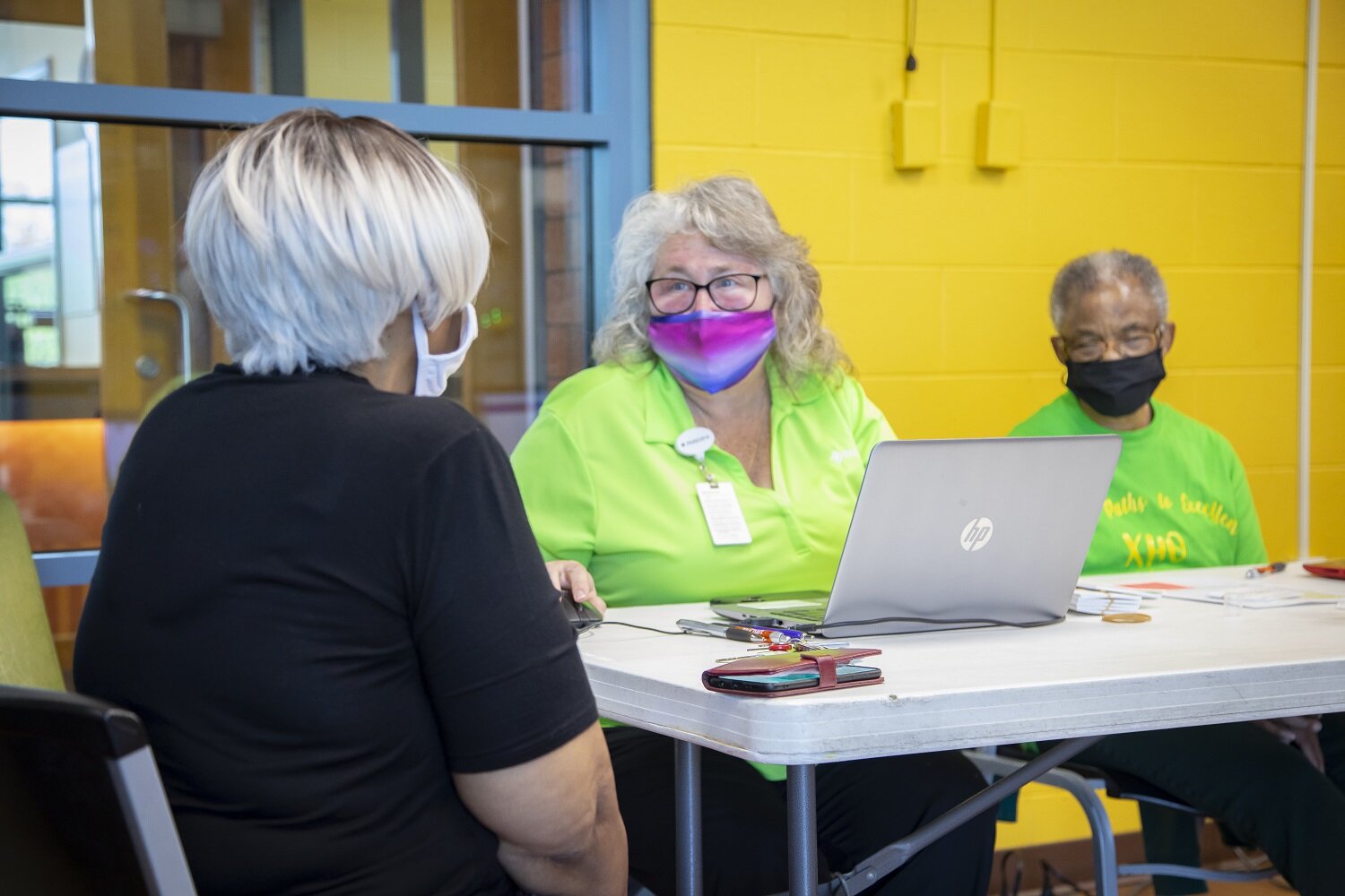 Jacqueline Barros, left, checks in for her vaccine with nurses Jan Moore, Parkview Community Nursing, and Stella Goodman, Chi Eta Phi nursing sorority.