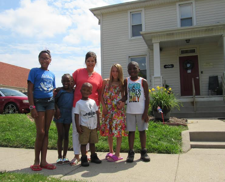 Denise Andorfer, center, poses with students from Vincent Village outside the Vincent House.