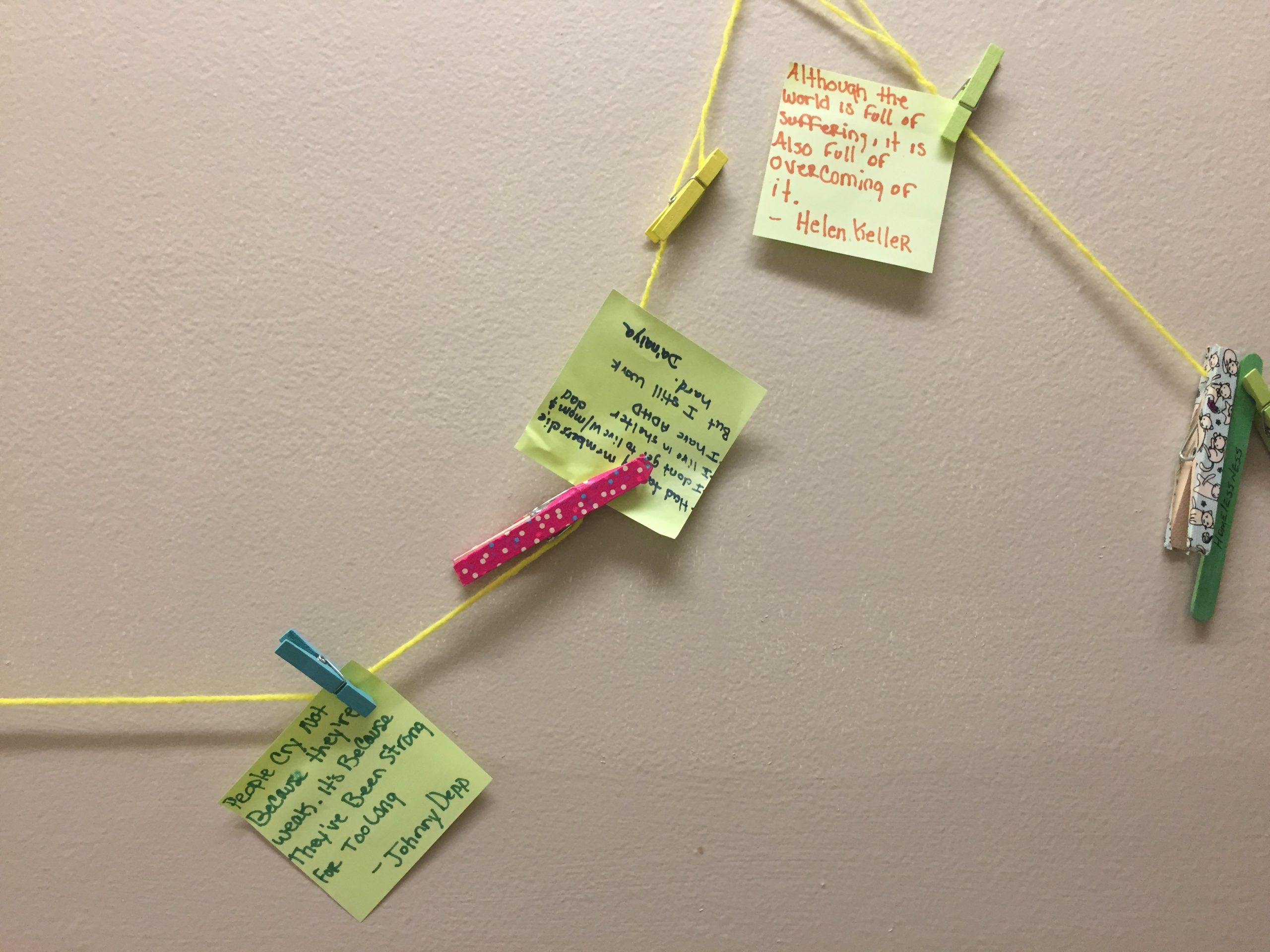 Vincent Village residents hang inspirational quotes on the shelter's wall.