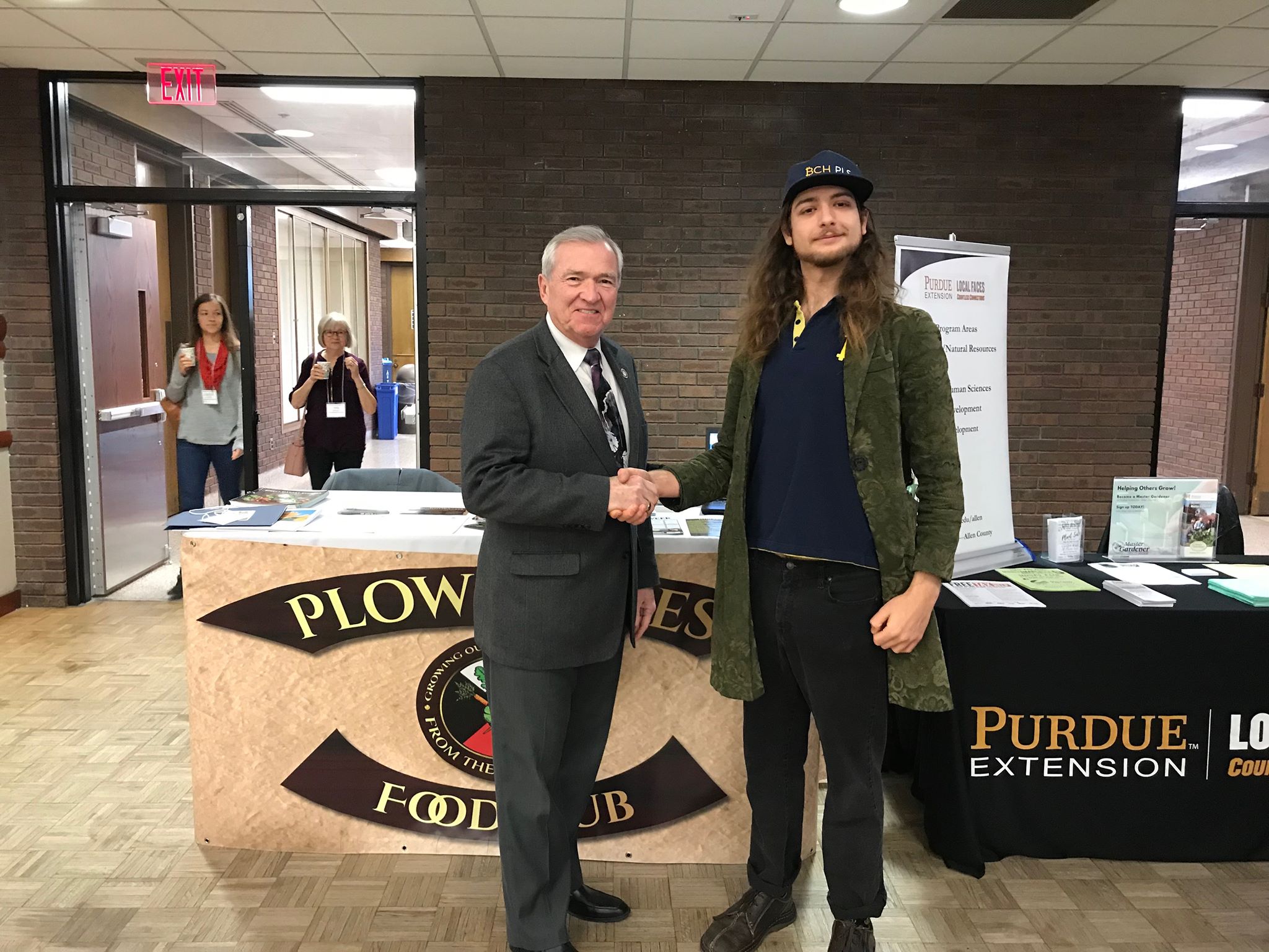 Representing Plowshares, Greene shakes hands with Fort Wayne's Mayor Tom Henry, left.