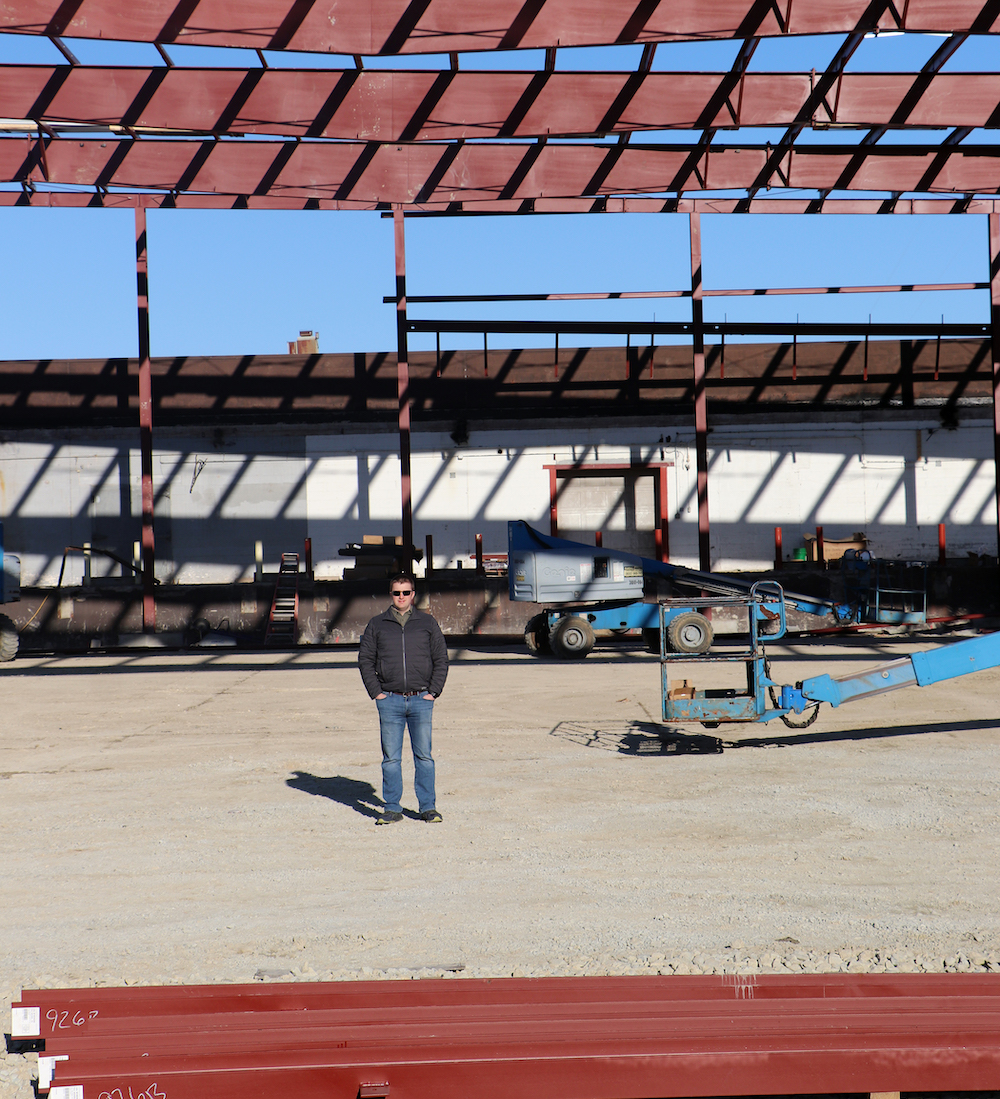 Jake Vaillancourt, an Officer at 10X, stands inside its future space.