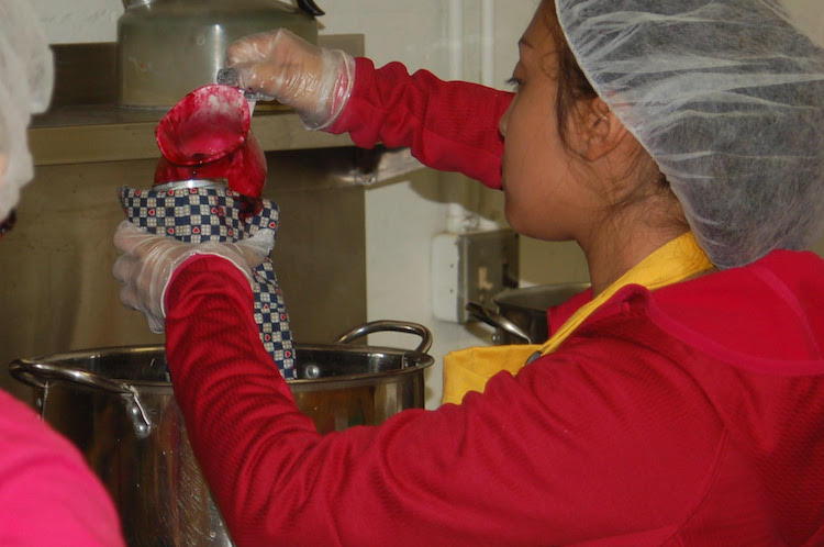 Out of a Jam students prepare jam at the Community Harvest Food Bank’s north facility at 1010 N. Coliseum Blvd.