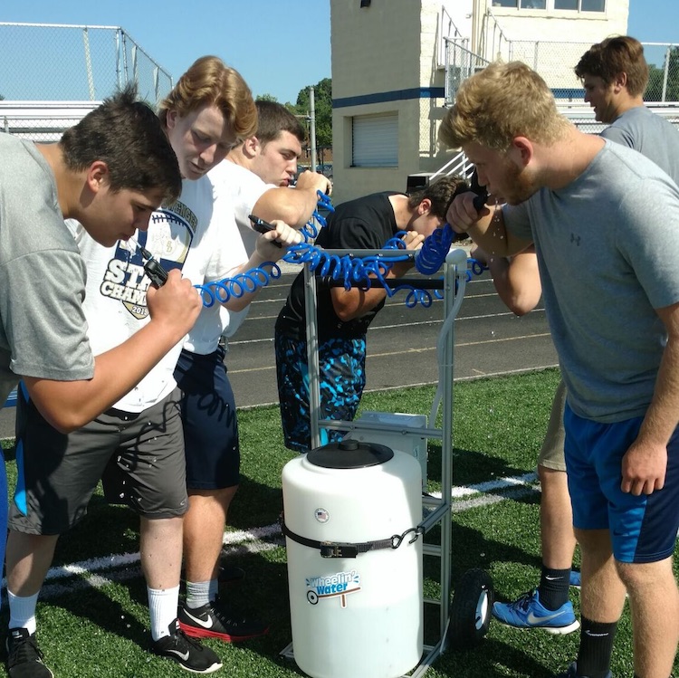 Dwenger football players using their Wheelin' Water cart.