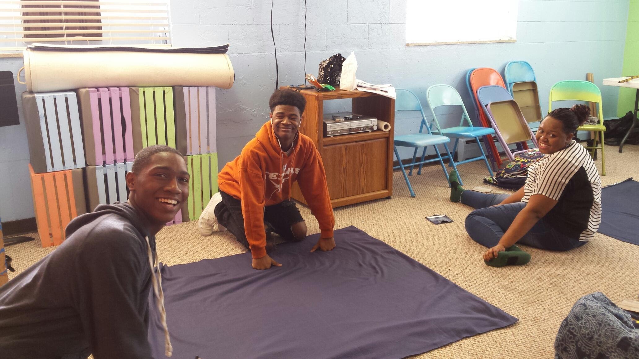 Representatives on site teach volunteers how to make fleece blankets for the homeless.