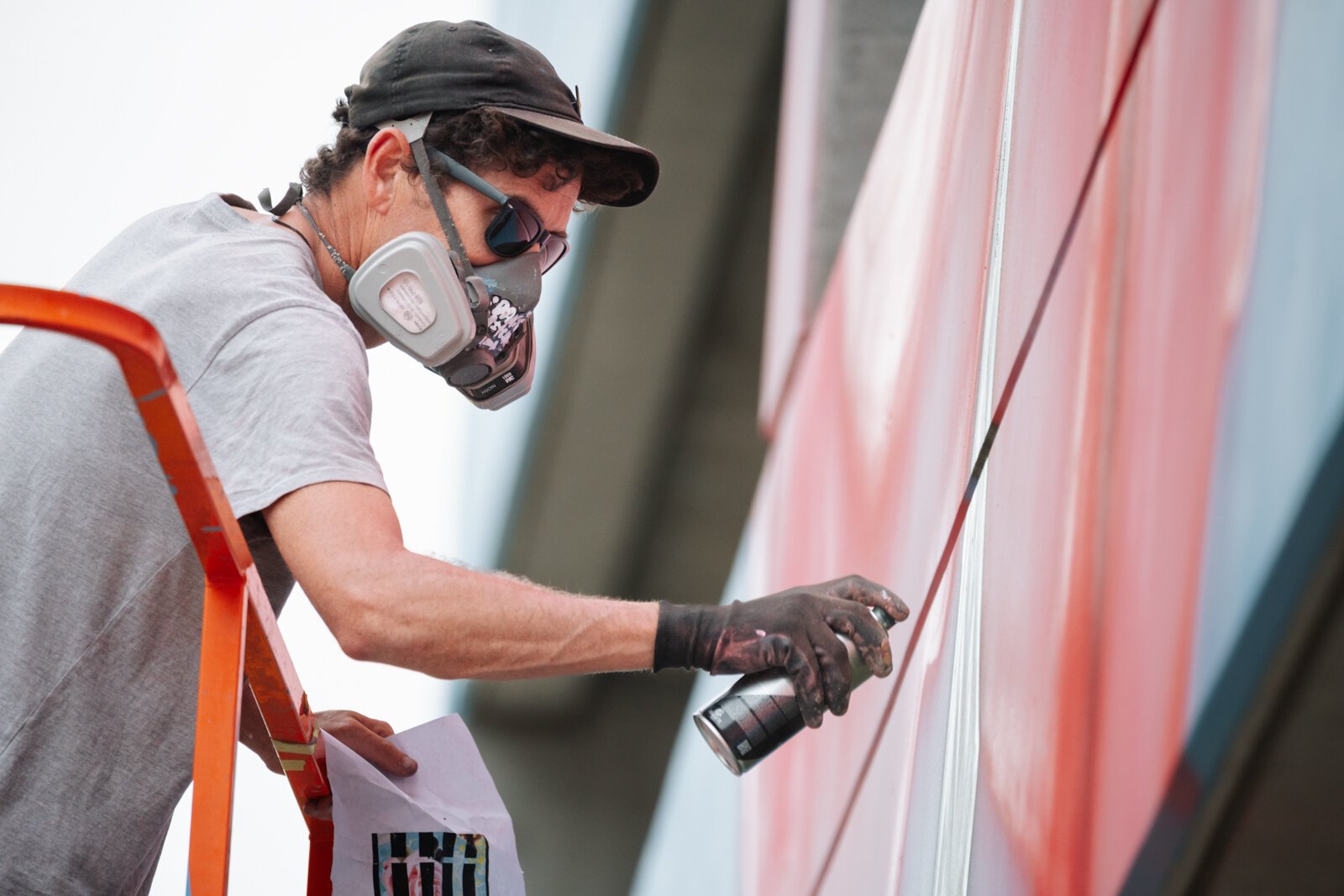 Muralist Damien Mitchell works on his 15,000 square foot mural on the Union Parking Garage at Electric Works.