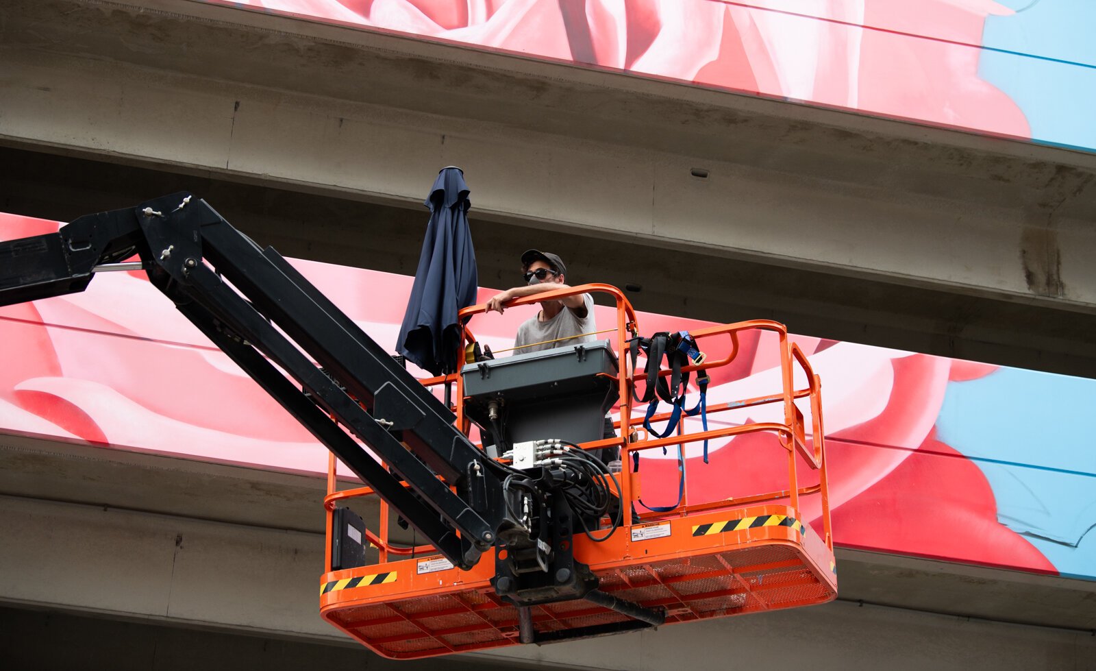 Muralist Damien Mitchell works on his 15,000 square foot mural on the Union Parking Garage at Electric Works.