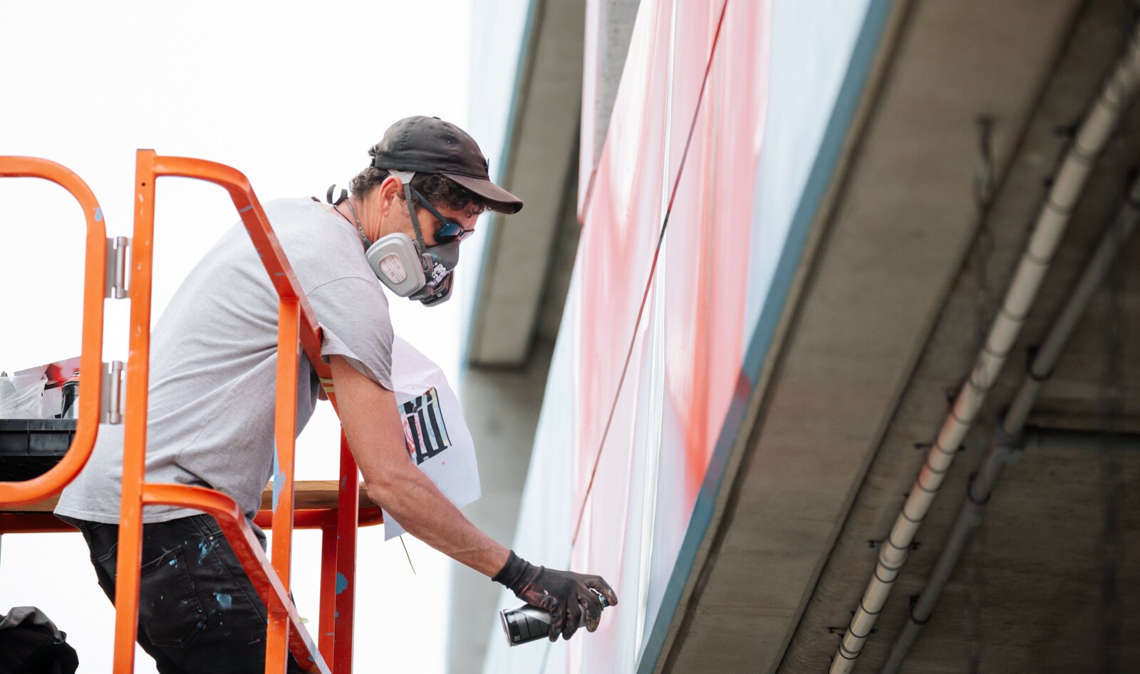 Muralist Damien Mitchell works on his 15,000 square foot mural on the Union Parking Garage at Electric Works.