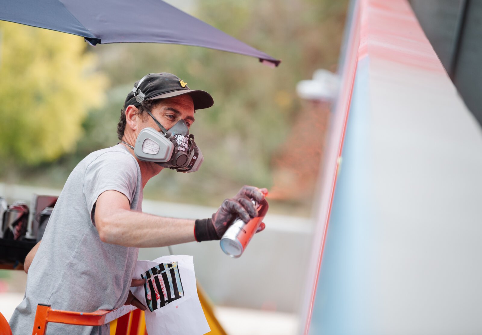 Muralist Damien Mitchell works on his 15,000 square foot mural on the Union Parking Garage at Electric Works.