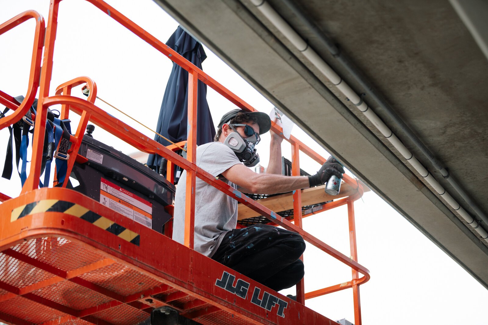 Muralist Damien Mitchell works on his 15,000 square foot mural on the Union Parking Garage at Electric Works.
