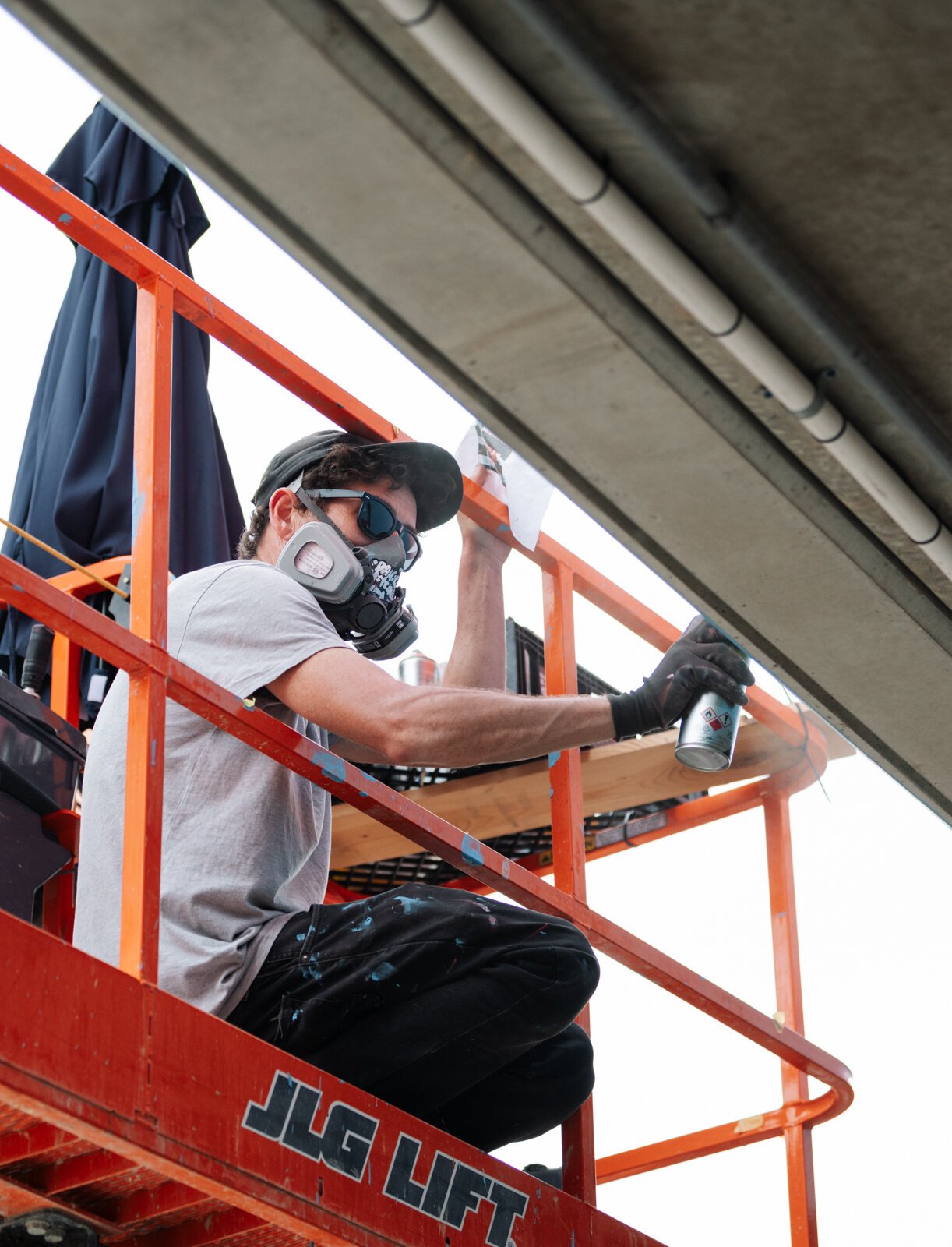 Muralist Damien Mitchell works on his 15,000 square foot mural on the Union Parking Garage at Electric Works.